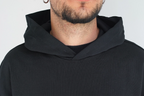 Dettaglio del cappuccio oversize strutturato con cuciture a rovescio a vista e bordi raw su felpa Empyrom
