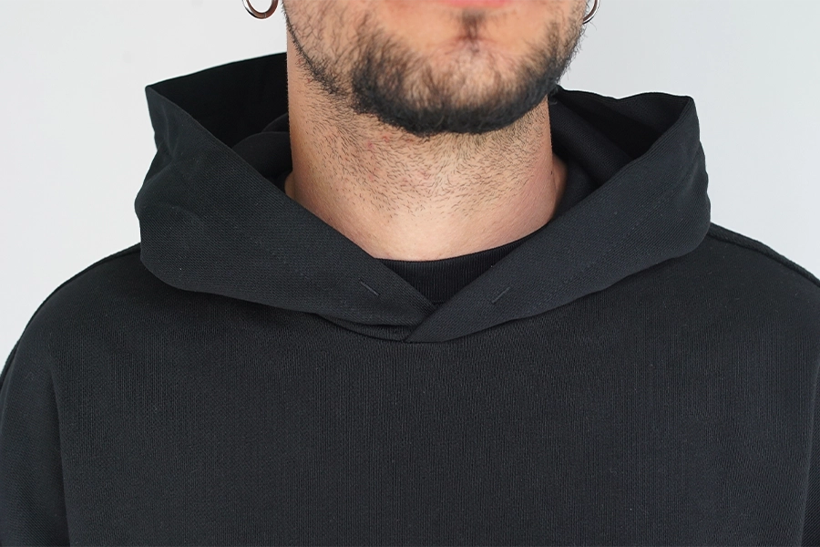 Dettaglio del cappuccio oversize strutturato con cuciture a rovescio a vista e bordi raw su felpa Empyrom