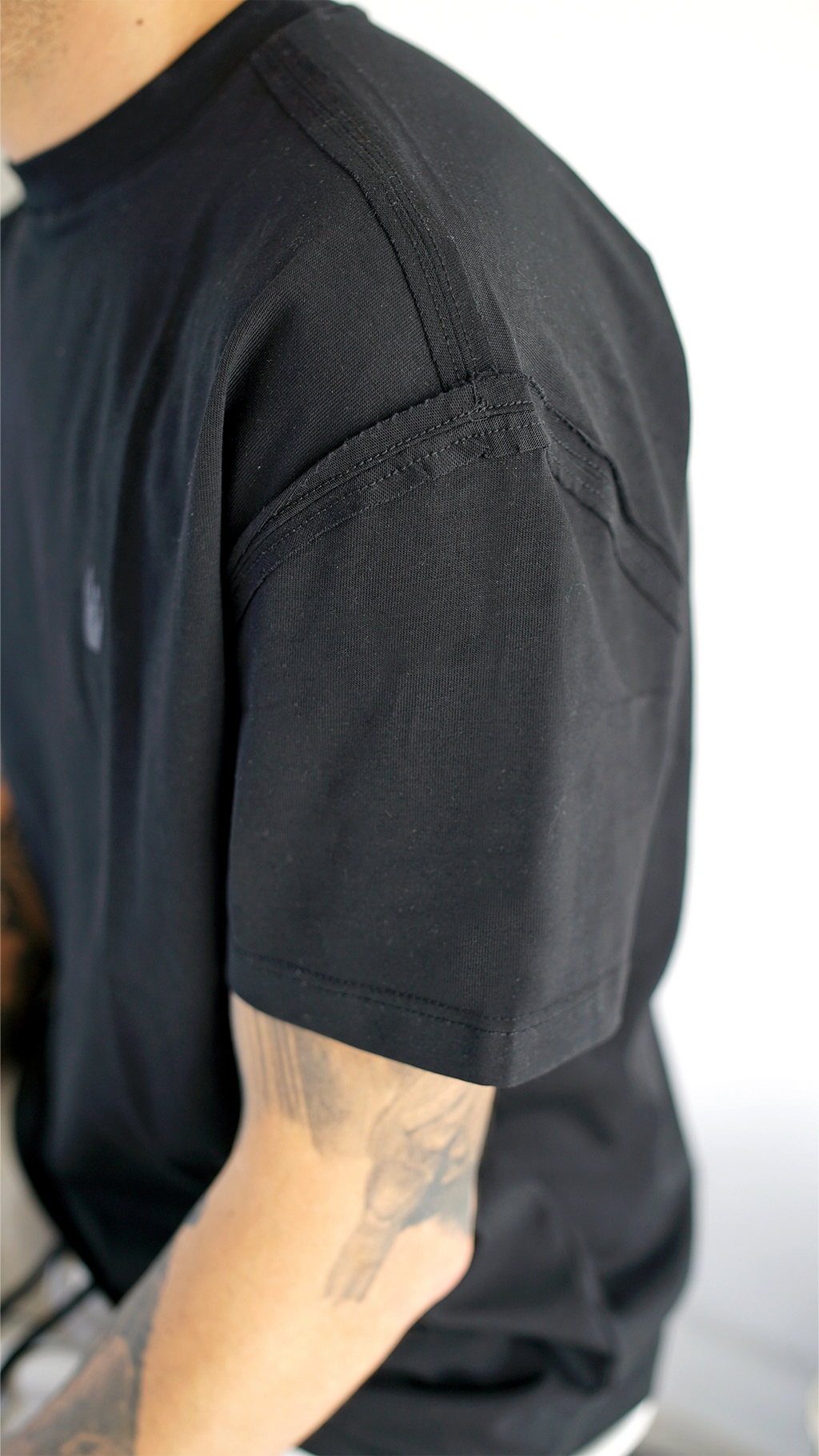 Dettaglio ravvicinato delle cuciture a rovescio esposte su t-shirt nera Made in Italy Empyrom
