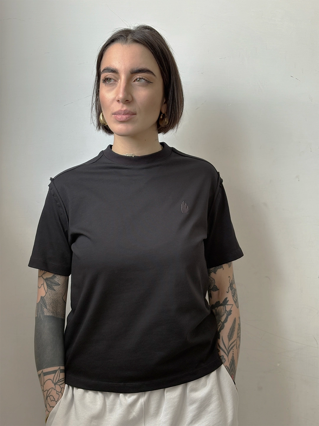 T-shirt nera cropped boxy fit firmata Empyrom con cuciture a rovescio esposte e logo nero ricamato